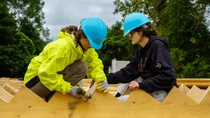 A Trekkie working with wooden planks to build stairs on a service trek trip