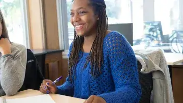 A student smiles while working in a classroom