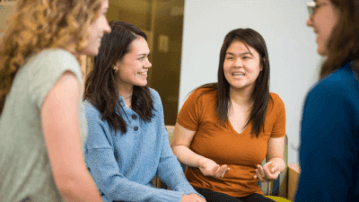 four people sitting and talking