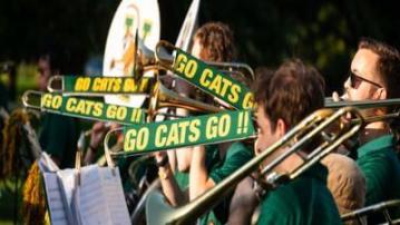 UVM marching band with trombone players and a visible music stand.