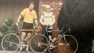 Two men standing next to bicycles