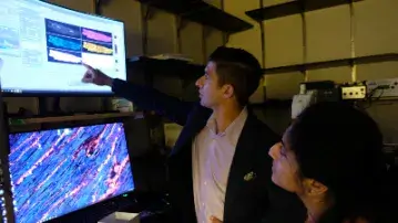 researcher points to a computer screen