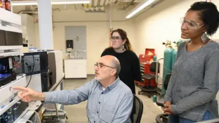 three researcher in a lab looking at computer screen