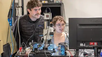 Two students using a semiconductor probe machine
