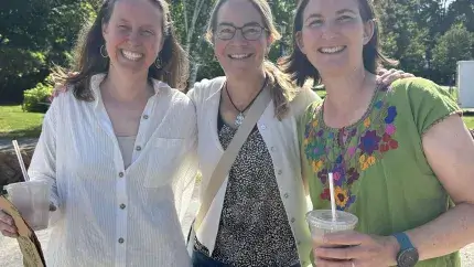 three employees smiling with smoothies