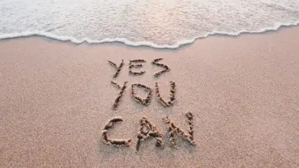 beach with water breaking, words in sand "yes you can"