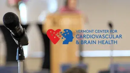 Blurred image featuring a microphone prominently displayed alongside the text "Vermont Center for Cardiovascular and Brain Health.