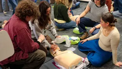 UVM Students practicing CPR on a CPR mannequin.