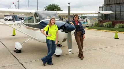 two people standing in front of airplane