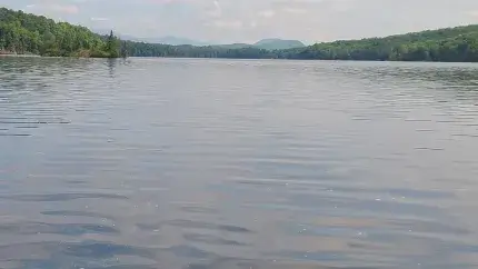 Water in a resevoir with land on sides and mountains in distance 