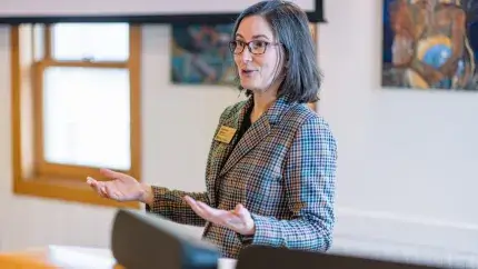 woman standing at podium giving a presentation