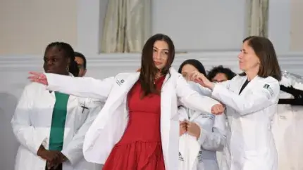 group of people on a stage wearing white doctors coats