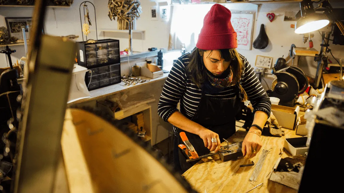 Generator Member works with woodworking tools in maker space