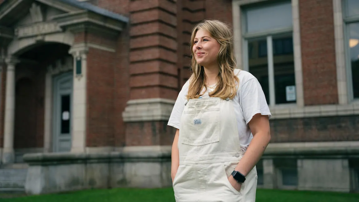 Alaura Rich standing in front of brick building looking hopeful