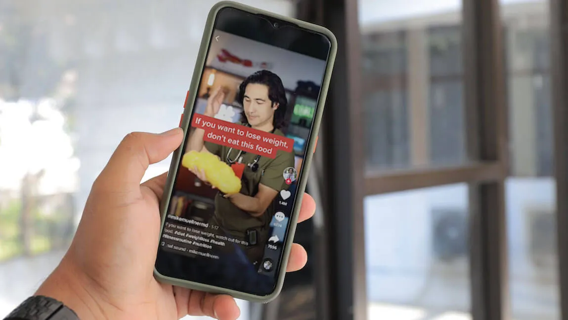 close up of a hand holding a phone with a TikTok video on the screen