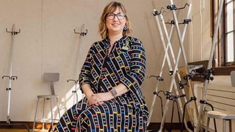 Kelly Helmstutler Di Dio seated in portrait, in a classroom setting