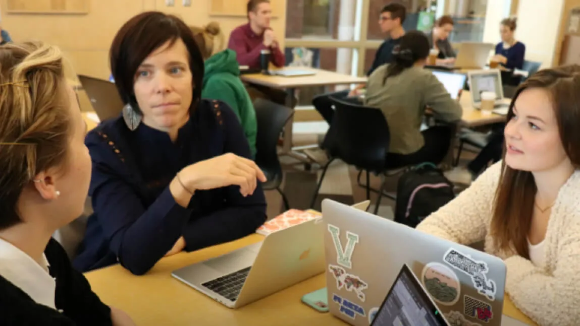 Deb Hinchey speaks to a student in class