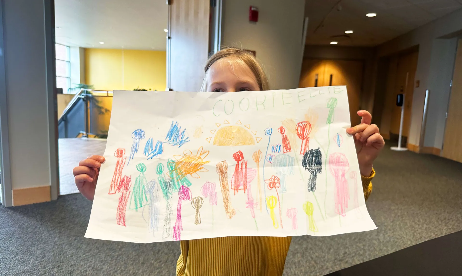 A young child shows off their drawing to the camera at the 2023 Childcare Mingler.