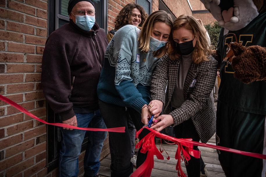 people cutting the ribbon outside of Rally Cat's Cupboard