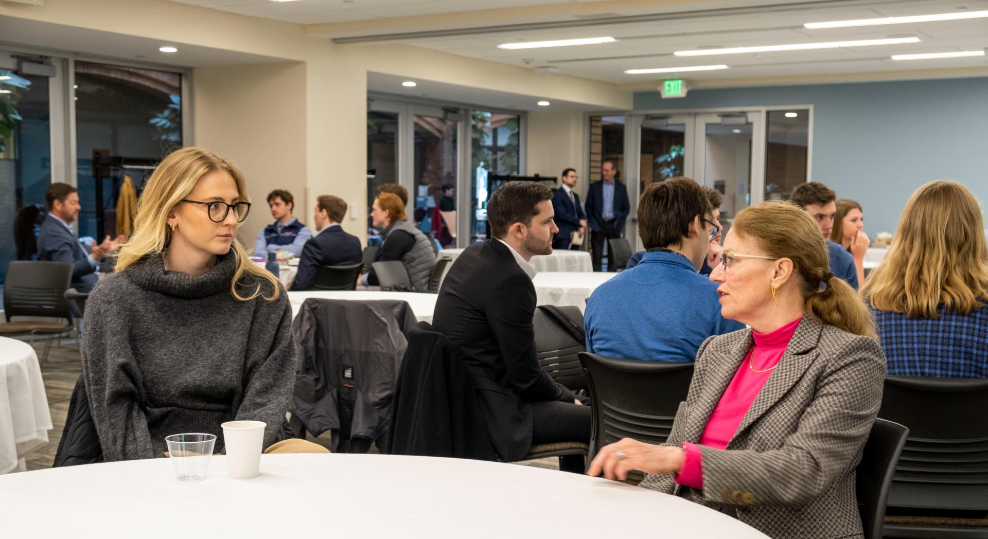 Panelist Claire Walker chats with a UVM student about career pathways in finance