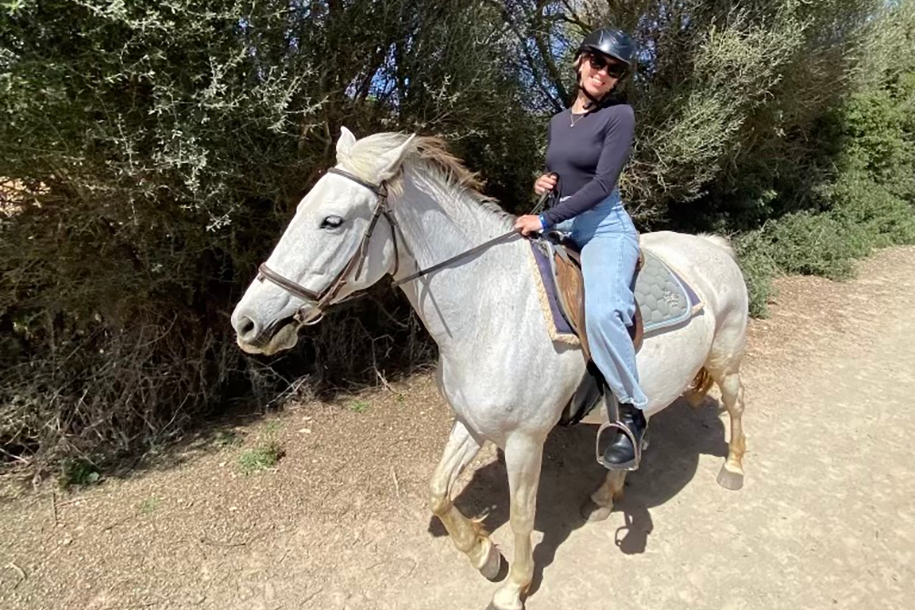 young woman riding a white horse