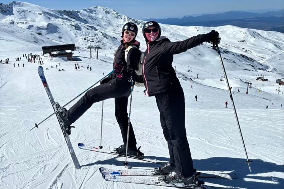 two young women having fun on a sunny, snowy day