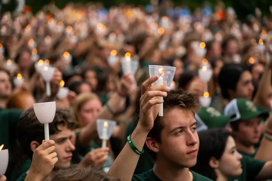 Students holding lit candles