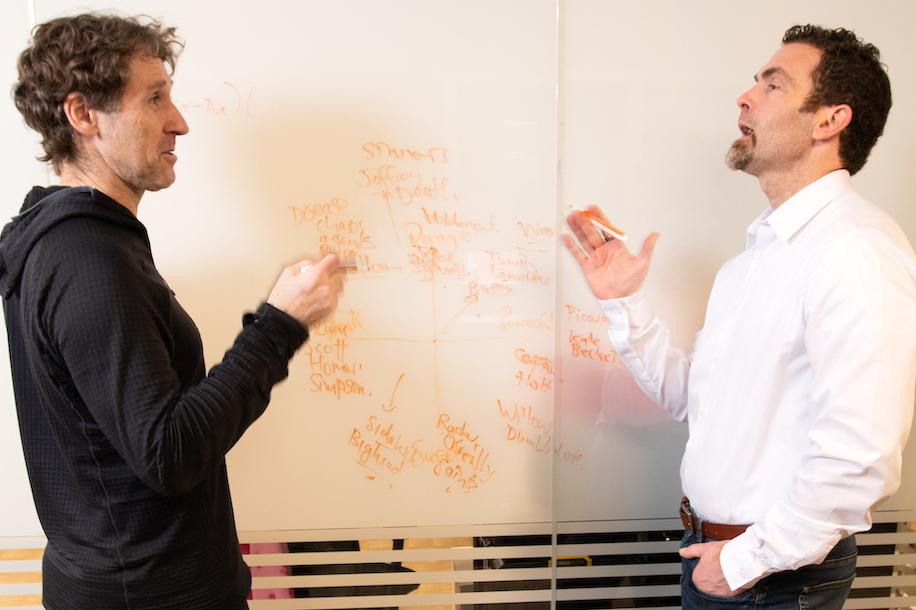 Peter Dodds and Chris Danforth talking in front of a whiteboard