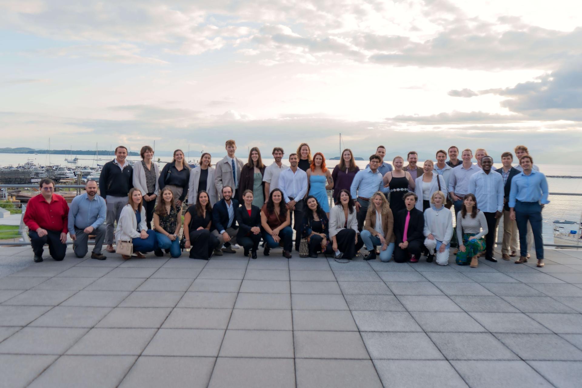 The UVM Sustainable Innovation MBA class of 2025 posed outside the ECHO Museum in front of Lake Champlain