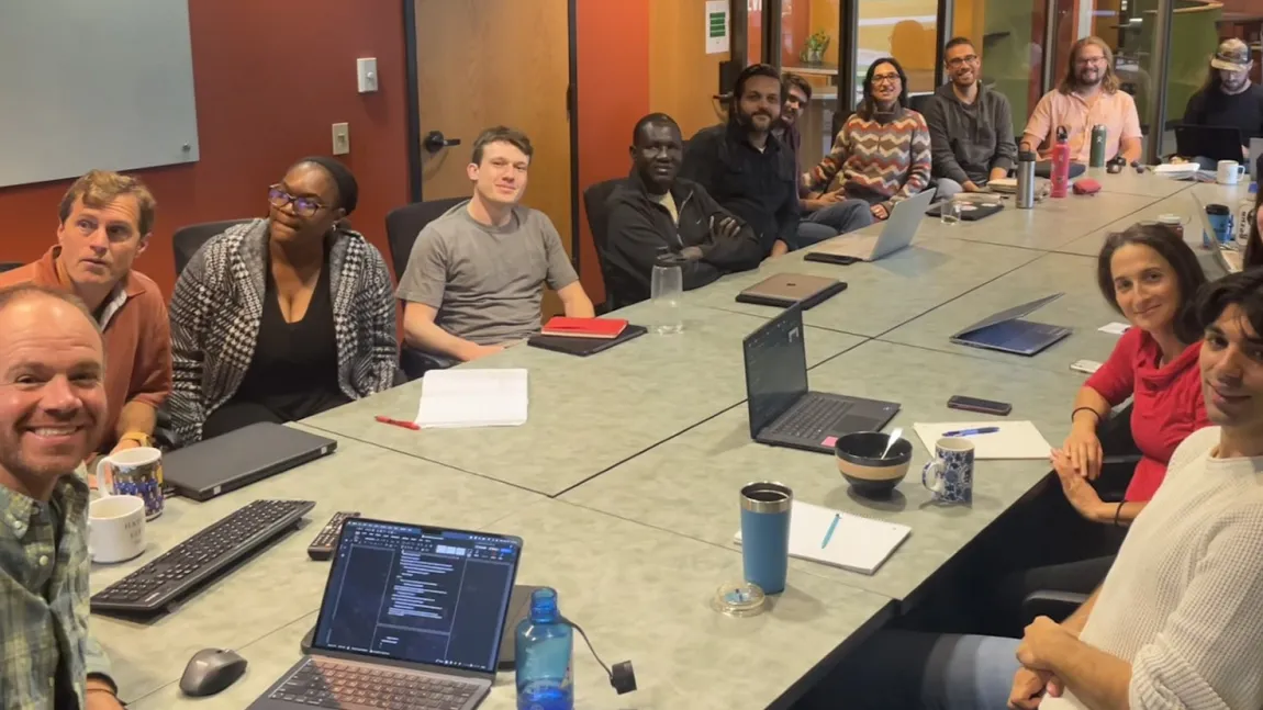 The University of Vermont Ecological Economics lab group sits at a long table