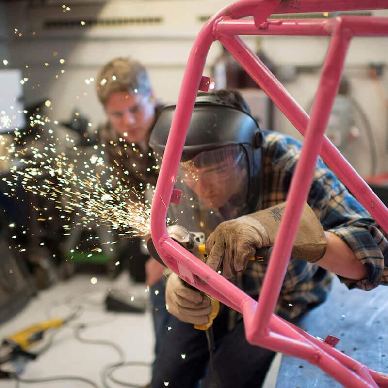 A student welds a metal frame.