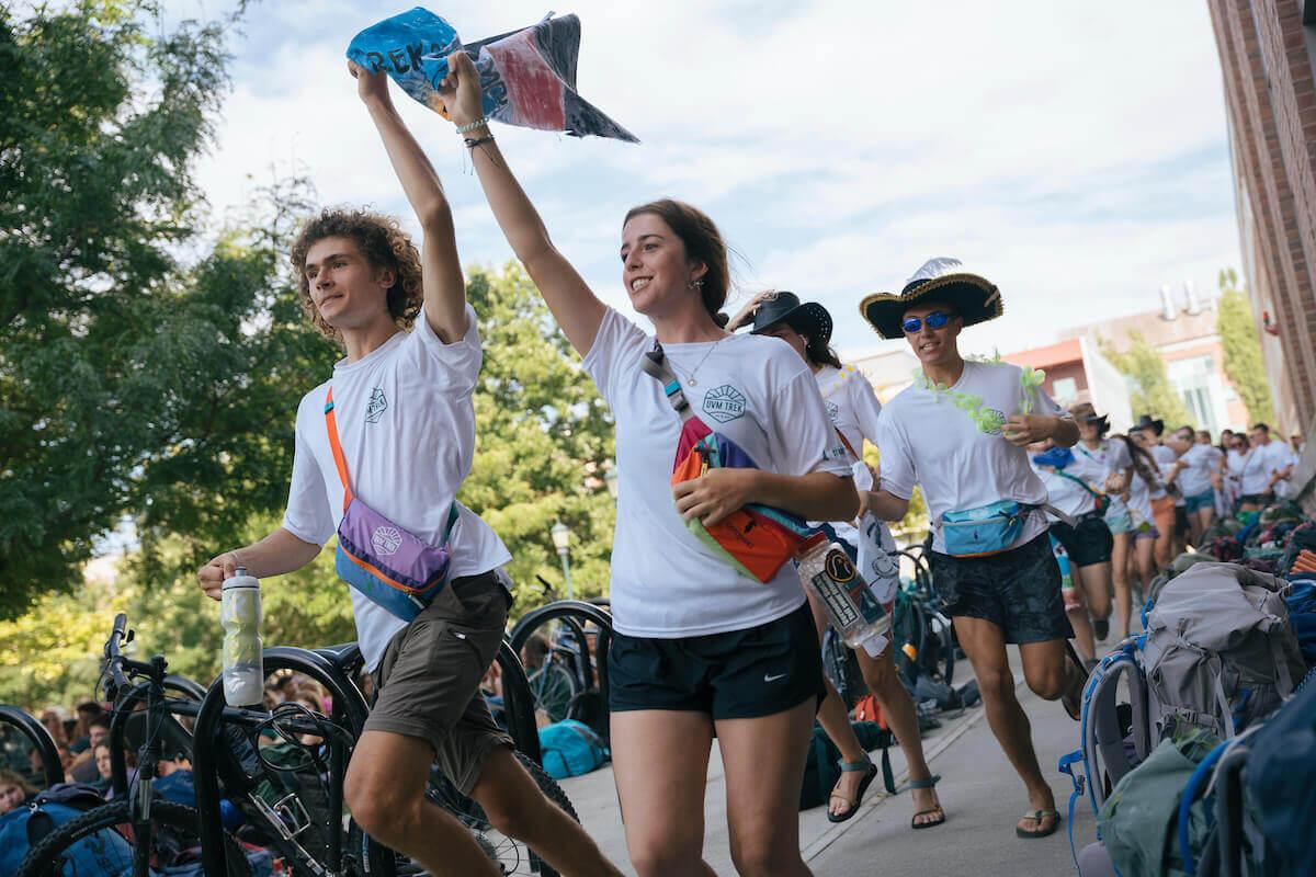 Students walk and cheer while waving a flag