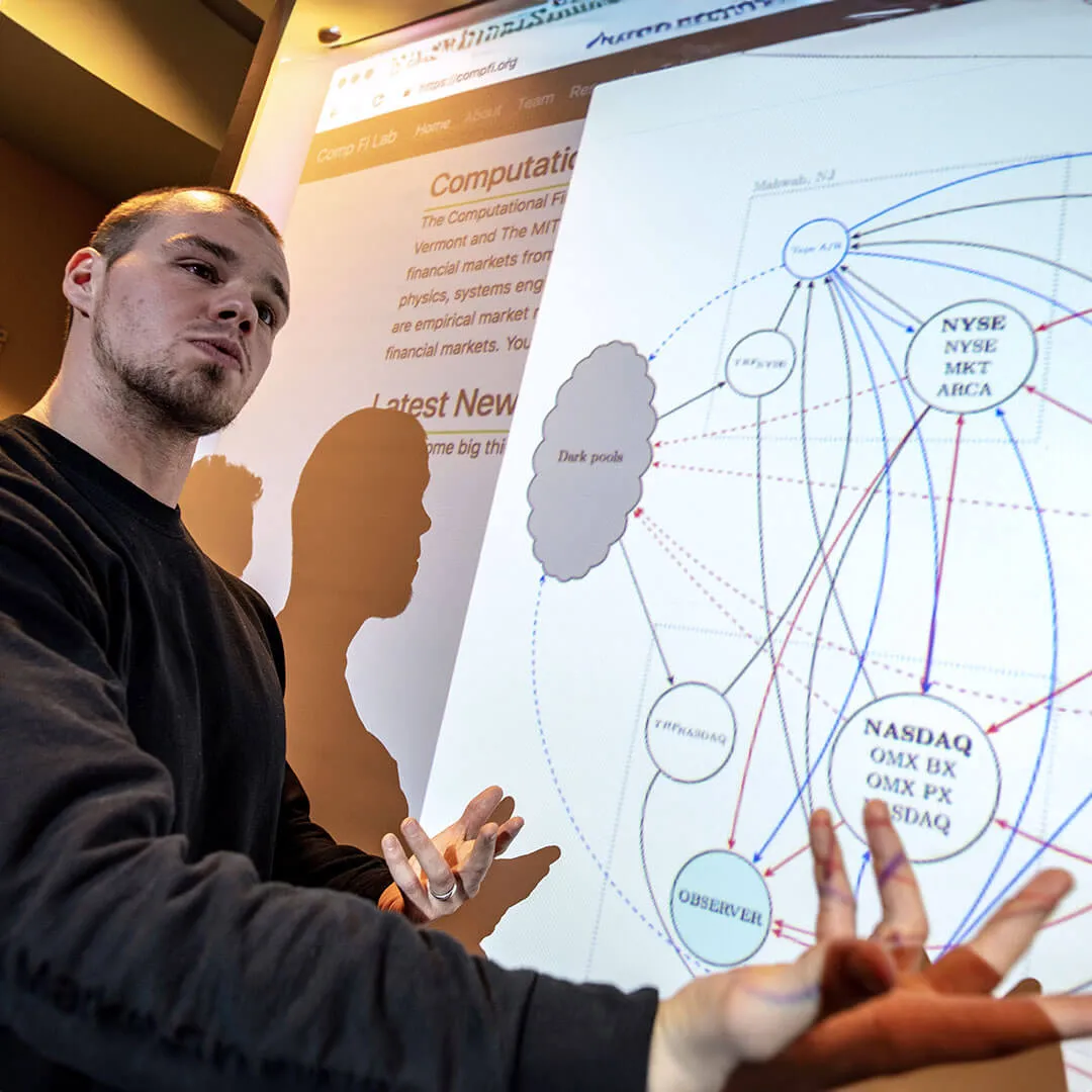 student presents in front of a projection of a graph