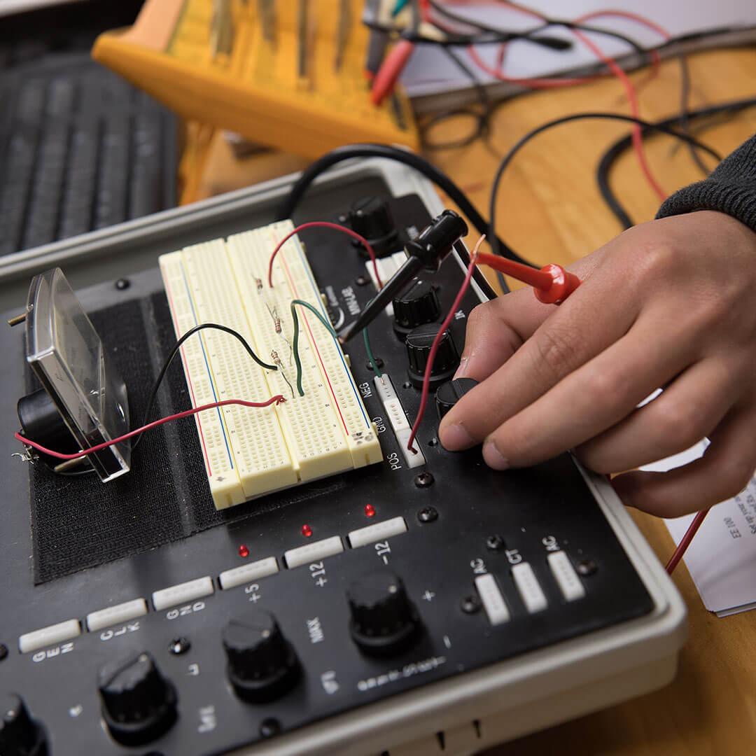 a hand works on an electrical device