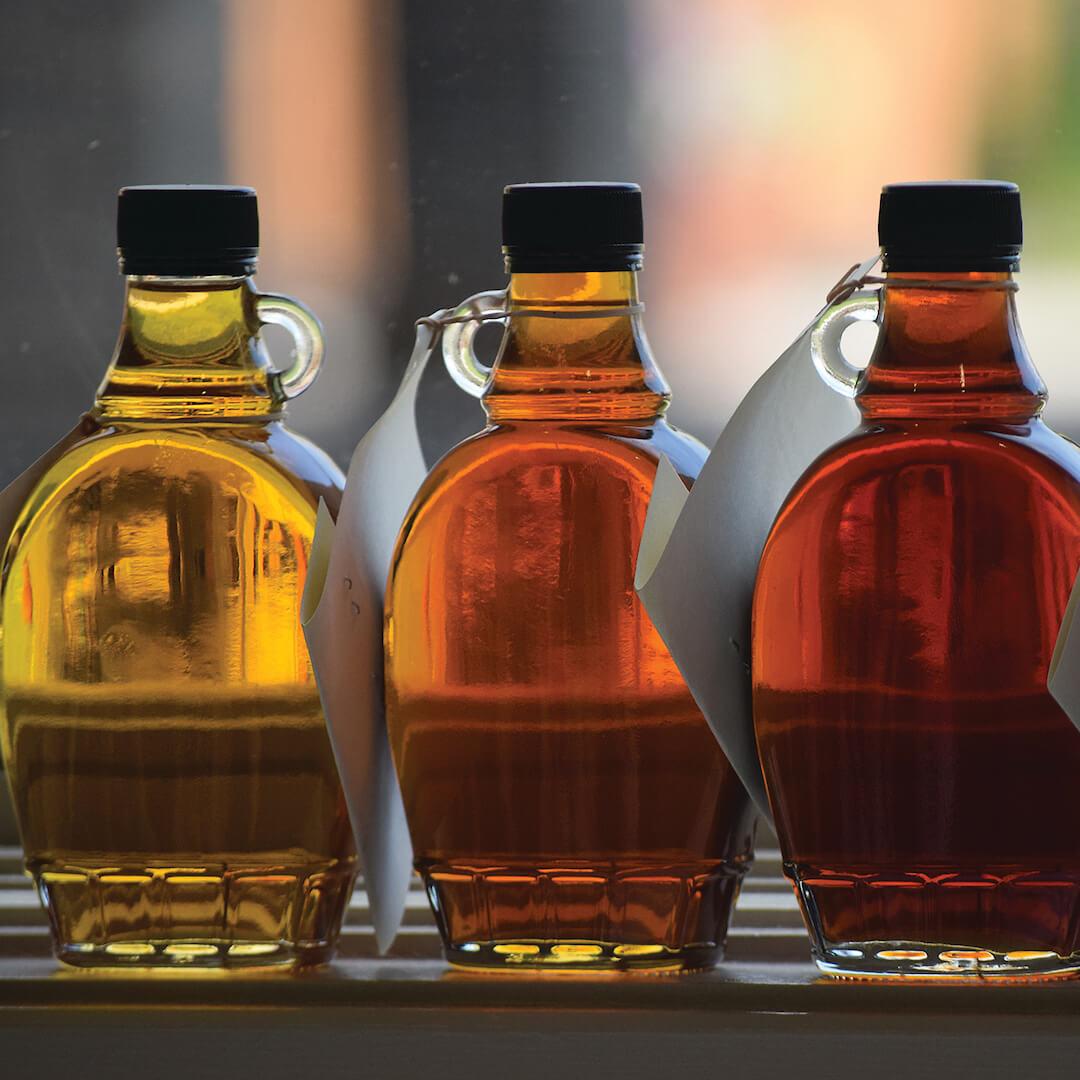 various grades maple syrup in glass bottles