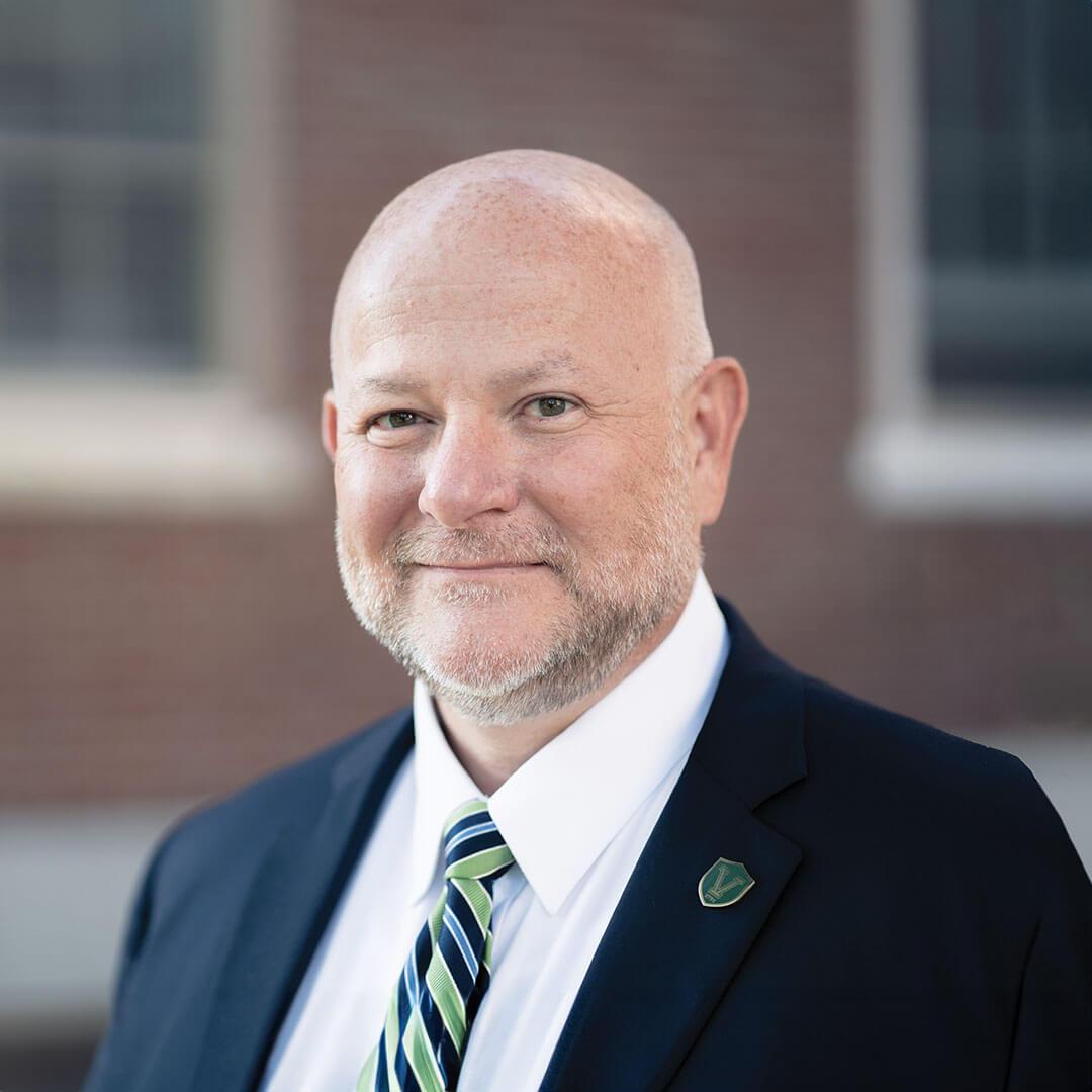 a man wearing a suit looks at the camera