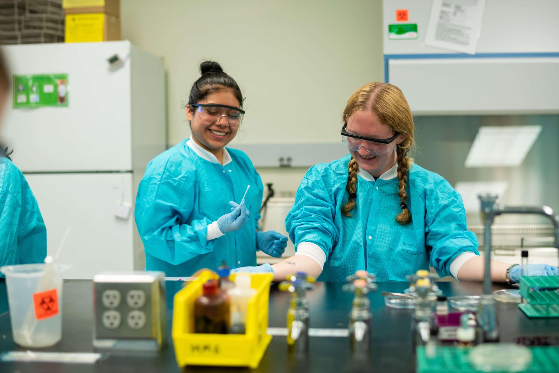 Two undergraduate students work in the lab on an experiment