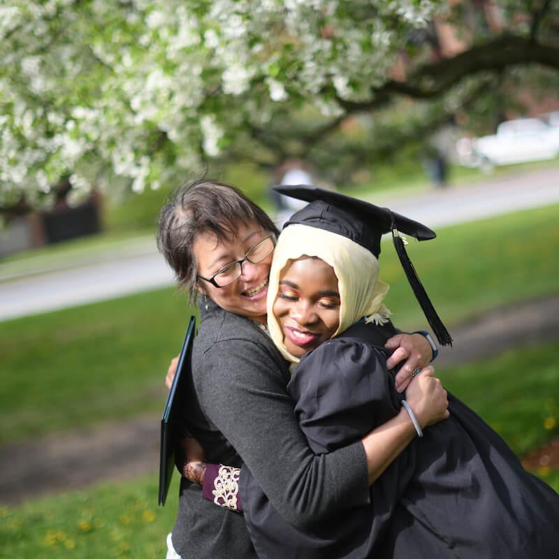 CESS graduate and faculty member hug after CESS Commencement.