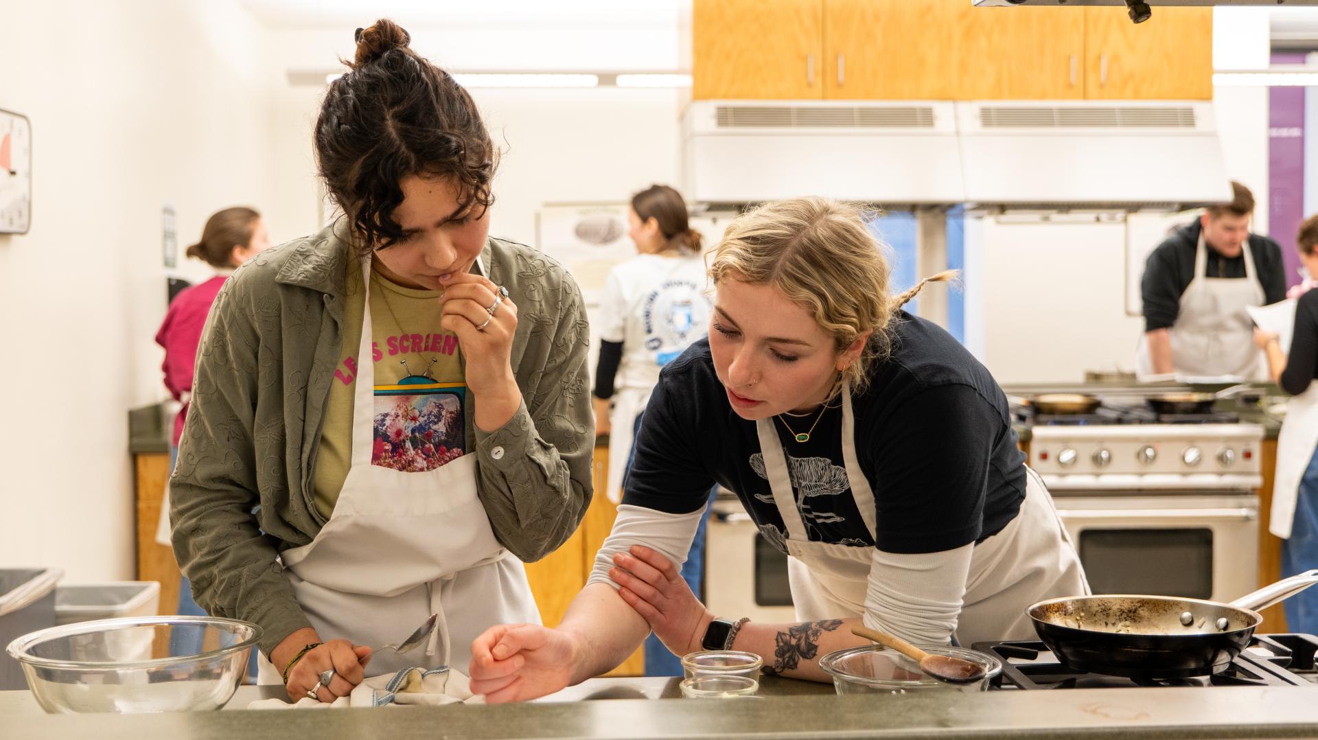 Two students working at a cooktop