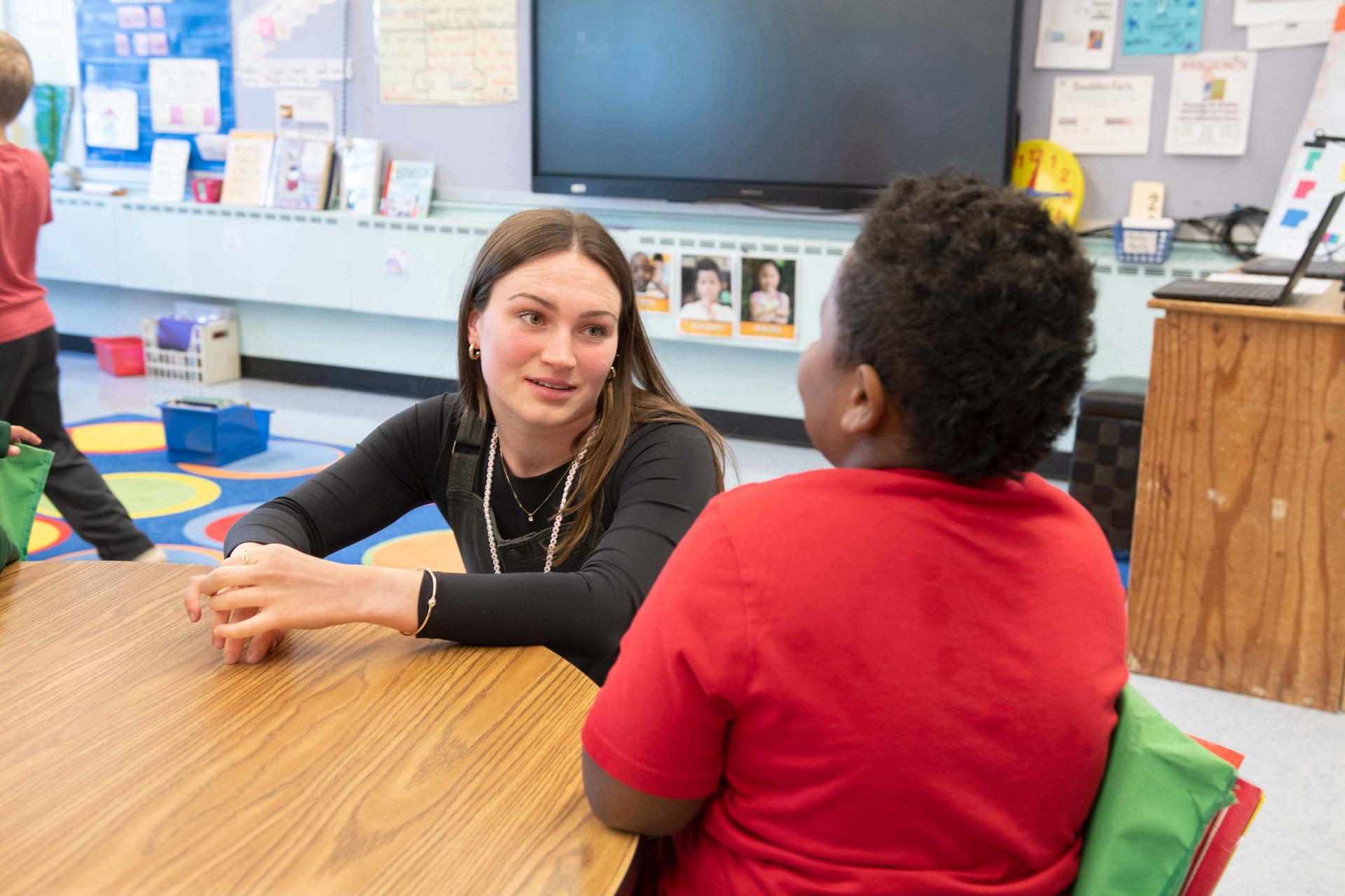 Ella McCarthy engaging with a young student during her student teaching internship.