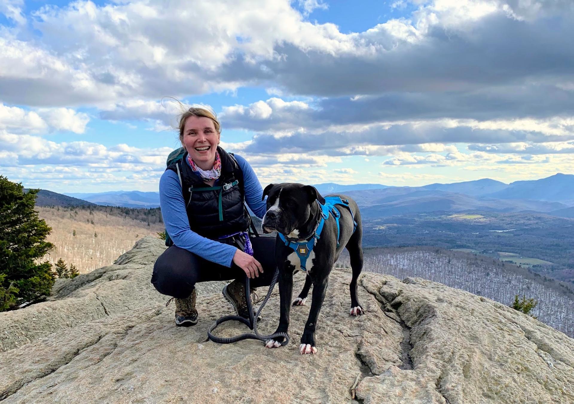 Molly Rolfe on a mountain top with her dog.