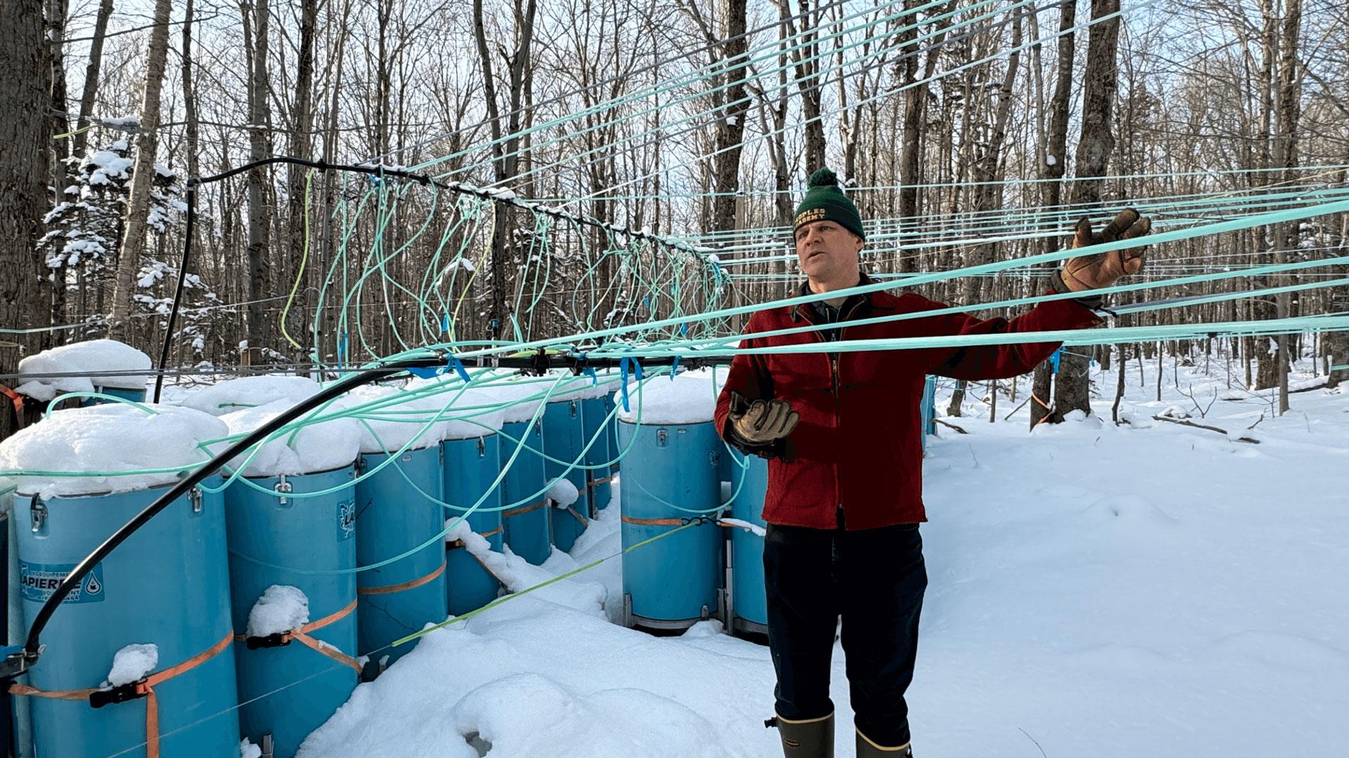 a man standing in the snow around tap lines