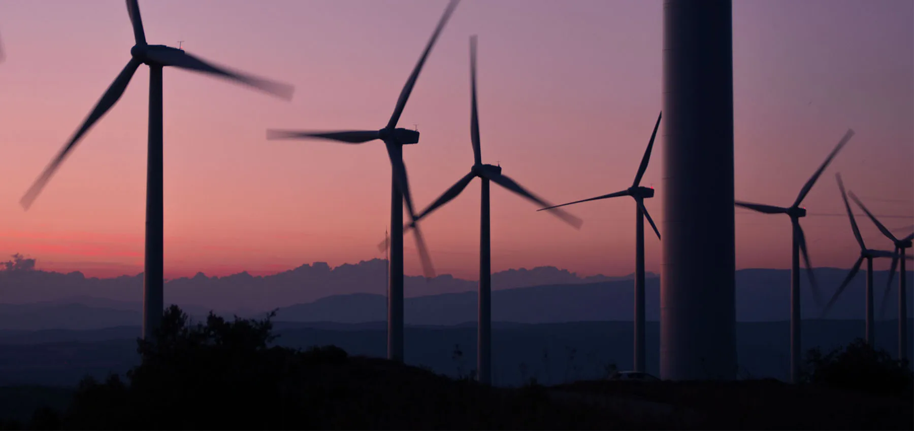 Wind Energy Farm Over a Mountain Sunset 