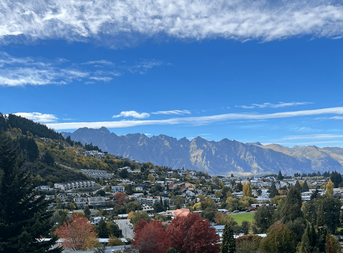 New Zealand skyline overlooking a village with mountains in the background.