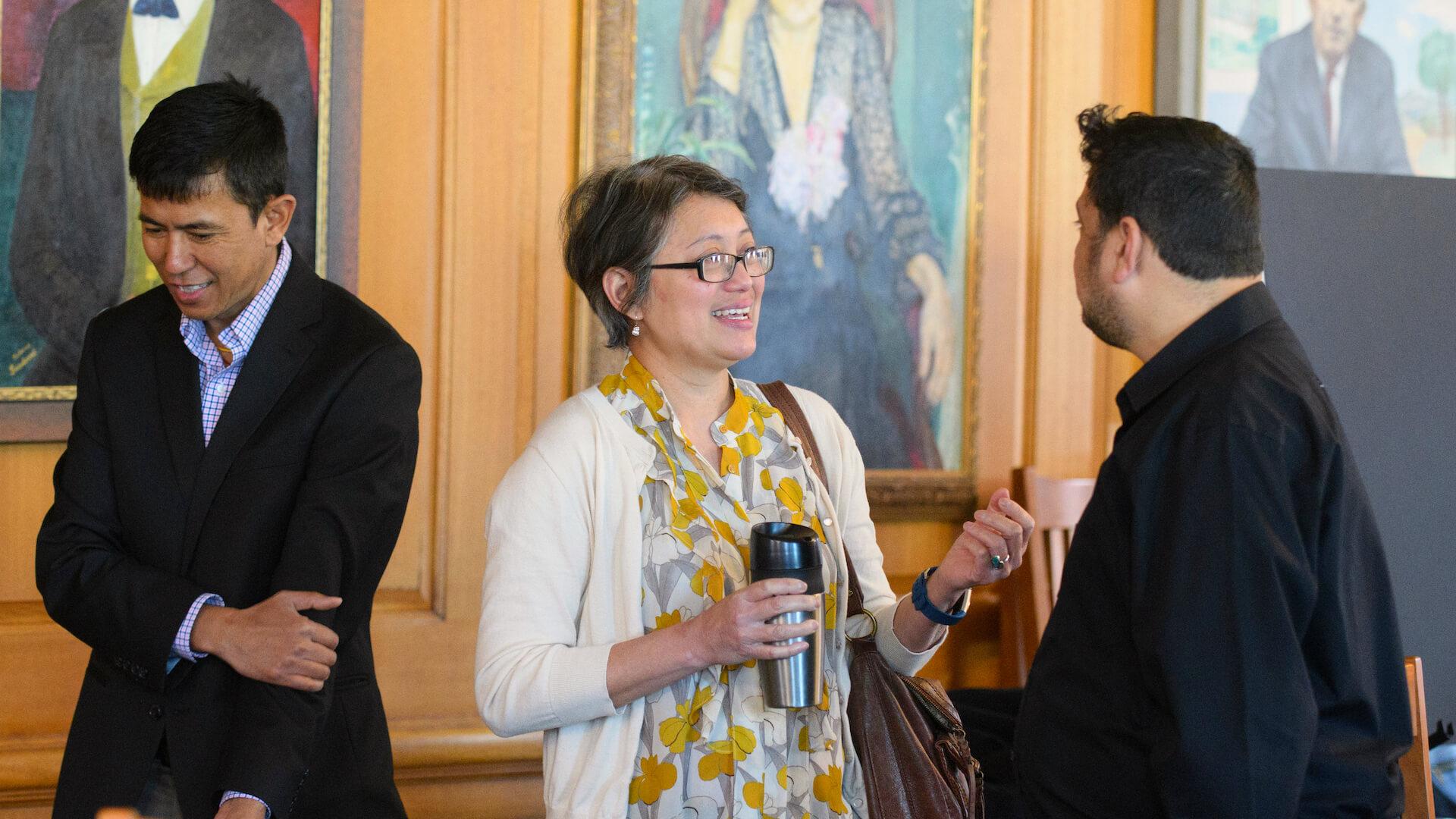 Faculty and graduate students conversing at CESS Research and Scholarship Symposium.