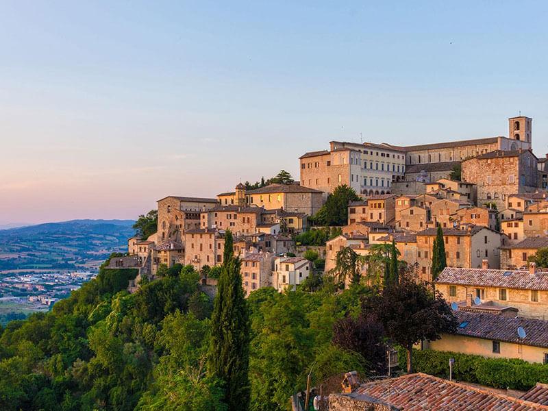 brick and clay buildings along a lush green cliffside