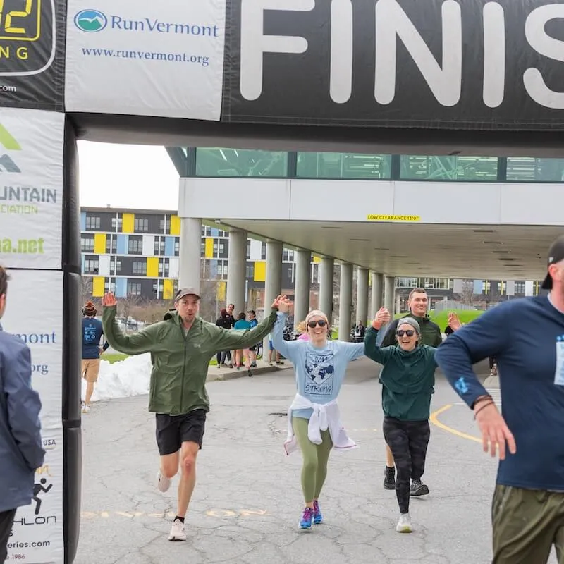 Students running across a finish line.