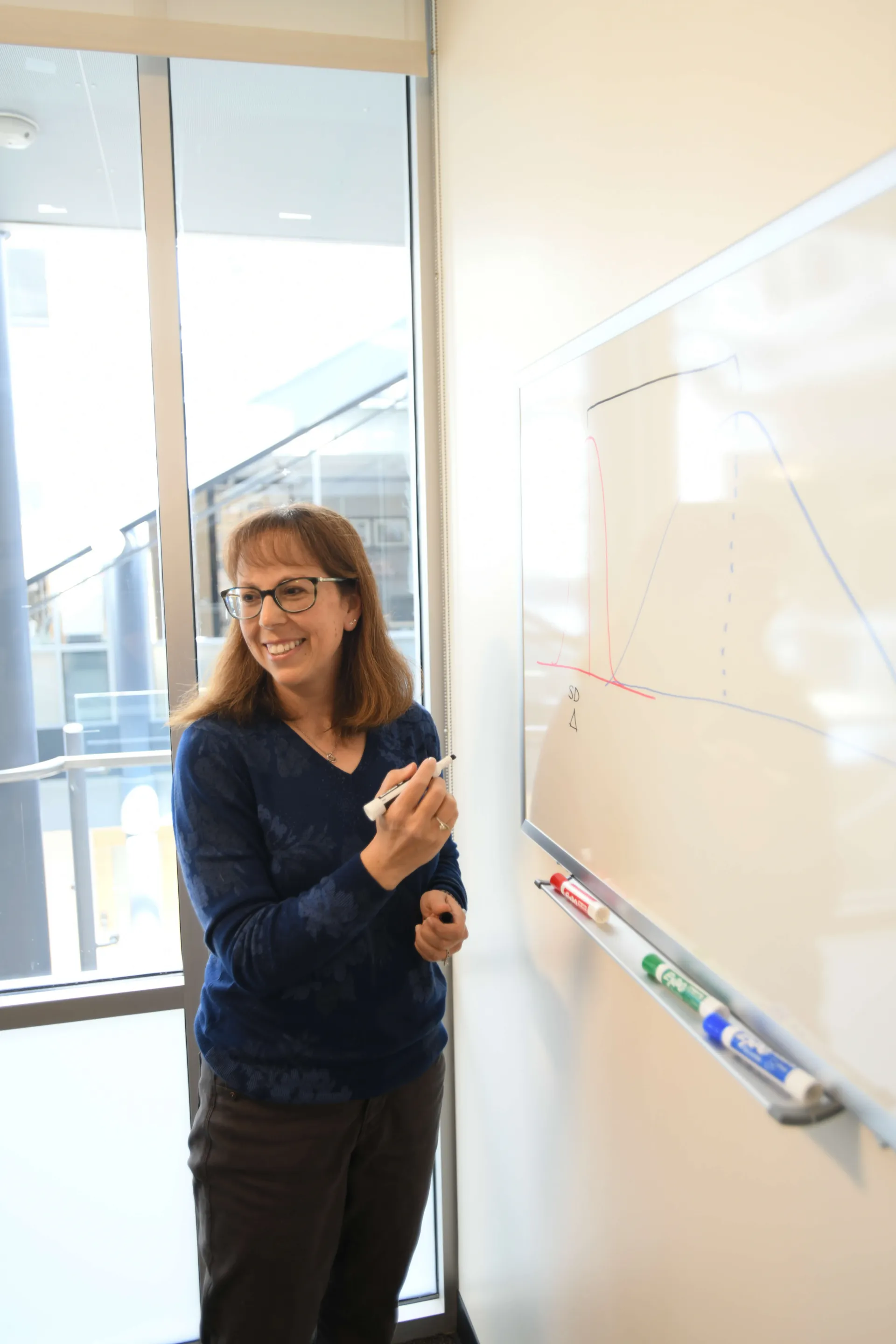 CTS professor writing at a whiteboard