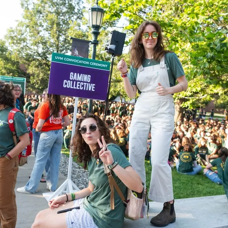 Two students standing near a purple sign that reads "Gaming Collective"