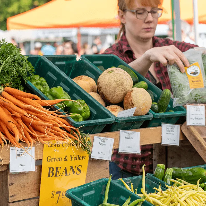 Farmers Market Booth with carrots and other vegetables